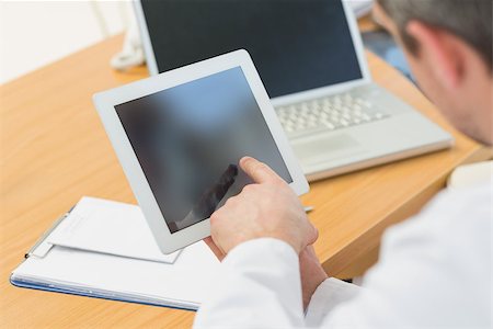 Extreme closeup of two doctors using laptop and digital tablet in meeting at the medical office Stock Photo - Budget Royalty-Free & Subscription, Code: 400-07274849