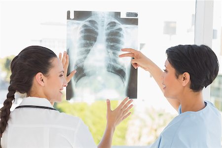 simsearch:400-07275966,k - Rear view of two female doctors examining xray in the medical office Foto de stock - Super Valor sin royalties y Suscripción, Código: 400-07274867