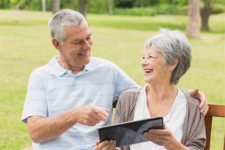 Cheerful senior woman and man using digital tablet on bench at the park Stock Photo - Budget Royalty-Free & Subscription, Code: 400-07274928