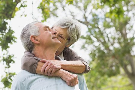 simsearch:400-07274981,k - Portrait of a senior woman embracing man from behind at the park Stock Photo - Budget Royalty-Free & Subscription, Code: 400-07274969