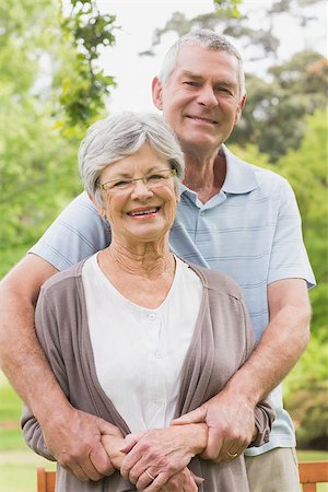 simsearch:400-07275058,k - Portrait of a senior man embracing woman from behind at the park Fotografie stock - Microstock e Abbonamento, Codice: 400-07274972