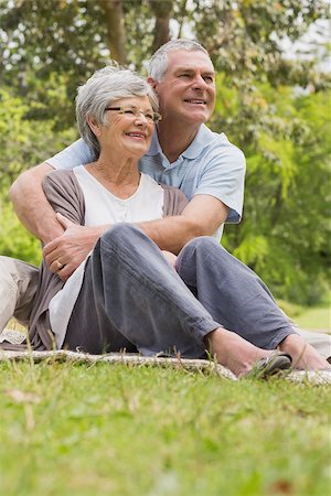 simsearch:400-07275058,k - Happy senior man embracing woman from behind at the park Fotografie stock - Microstock e Abbonamento, Codice: 400-07274985