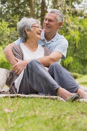 simsearch:400-07275058,k - Happy senior man embracing woman from behind at the park Fotografie stock - Microstock e Abbonamento, Codice: 400-07274986