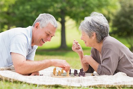 enthusiastic senior couple on amusement park - Side view of a happy senior couple playing chess at the park Stock Photo - Budget Royalty-Free & Subscription, Code: 400-07275015