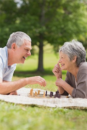 enthusiastic senior couple on amusement park - Side view of a happy senior couple playing chess at the park Stock Photo - Budget Royalty-Free & Subscription, Code: 400-07275016