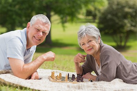 enthusiastic senior couple on amusement park - Side view of a happy senior couple playing chess at the park Stock Photo - Budget Royalty-Free & Subscription, Code: 400-07275018