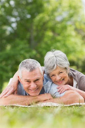 simsearch:400-07275058,k - Portrait of a smiling relaxed senior couple lying in the park Fotografie stock - Microstock e Abbonamento, Codice: 400-07275012