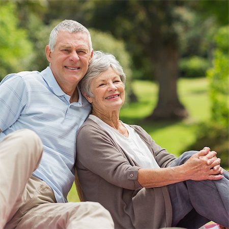 simsearch:400-07275058,k - Portrait of a smiling senior couple sitting at the park Fotografie stock - Microstock e Abbonamento, Codice: 400-07275047