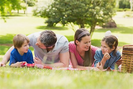 simsearch:400-07275176,k - Portrait of a smiling couple with young kids lying on grass in the park Stock Photo - Budget Royalty-Free & Subscription, Code: 400-07275110