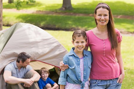 simsearch:400-07275176,k - Portrait of mother and daughter with family behind in the park Stock Photo - Budget Royalty-Free & Subscription, Code: 400-07275113