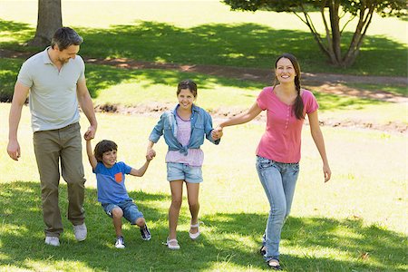simsearch:400-07275176,k - Portrait of a family of four holding hands and walking at the park Stock Photo - Budget Royalty-Free & Subscription, Code: 400-07275134