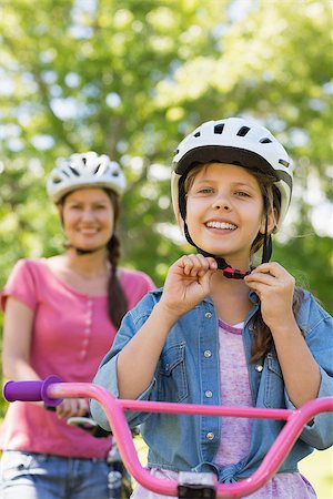 Portrait of a smiling woman with her daughter riding a bicycle Stock Photo - Budget Royalty-Free & Subscription, Code: 400-07275143