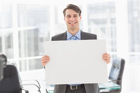 simsearch:400-07275251,k - Handsome happy businessman holding placard in the office Stock Photo - Budget Royalty-Free & Subscription, Code: 400-07275254