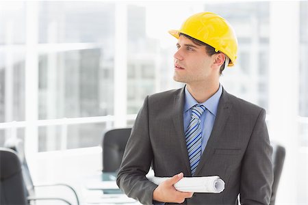 simsearch:400-07275251,k - Serious architect holding blueprints looking up in the office Stock Photo - Budget Royalty-Free & Subscription, Code: 400-07275264