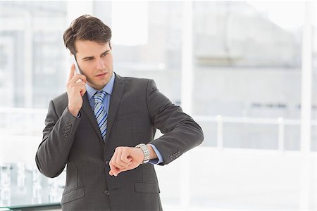 simsearch:400-07139155,k - Businessman checking the time on the phone in the office Stock Photo - Budget Royalty-Free & Subscription, Code: 400-07275268