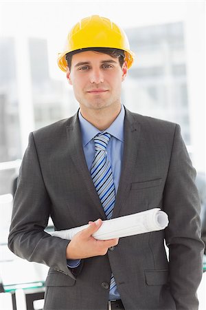 simsearch:400-07275251,k - Happy architect holding blueprints looking at camera in the office Stock Photo - Budget Royalty-Free & Subscription, Code: 400-07275261