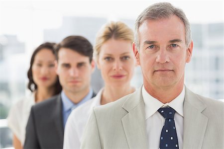 simsearch:400-07274497,k - Stern business team standing in a line in the office Stock Photo - Budget Royalty-Free & Subscription, Code: 400-07275309