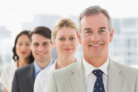 simsearch:400-07274497,k - Smiling business team standing in a line in the office Stock Photo - Budget Royalty-Free & Subscription, Code: 400-07275310