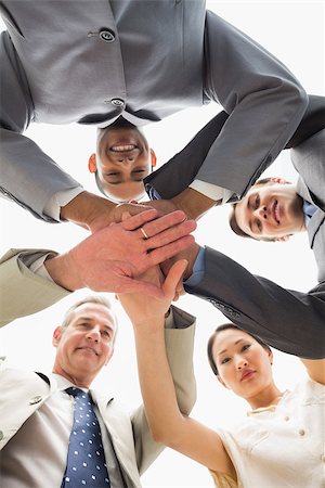 simsearch:400-07274497,k - Business team smiling down at the camera with hands together in the office Stock Photo - Budget Royalty-Free & Subscription, Code: 400-07275334