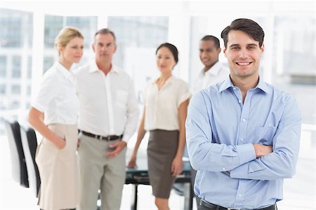 simsearch:400-07275394,k - Happy businessman standing with team behind him in the office Stock Photo - Budget Royalty-Free & Subscription, Code: 400-07275367