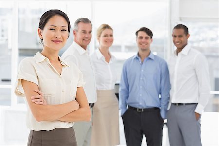 simsearch:400-07275394,k - Smiling businesswoman standing with team behind her in the office Stock Photo - Budget Royalty-Free & Subscription, Code: 400-07275369