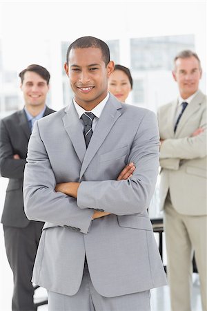 simsearch:400-07274497,k - Businessman smiling at camera with team behind him in the office Stock Photo - Budget Royalty-Free & Subscription, Code: 400-07275360