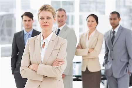simsearch:400-07275394,k - Businesswoman looking at camera with team behind her in the office Stock Photo - Budget Royalty-Free & Subscription, Code: 400-07275361