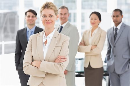simsearch:400-07275394,k - Businesswoman smiling at camera with team behind her in the office Stock Photo - Budget Royalty-Free & Subscription, Code: 400-07275362