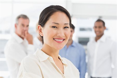 simsearch:400-07275394,k - Happy asian businesswoman standing with team behind her in the office Stock Photo - Budget Royalty-Free & Subscription, Code: 400-07275370