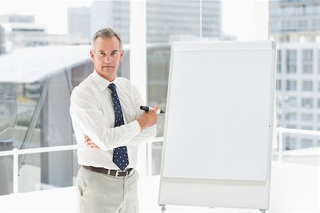 simsearch:400-07927898,k - Stern businessman standing at whiteboard with marker in the office Stock Photo - Budget Royalty-Free & Subscription, Code: 400-07275421