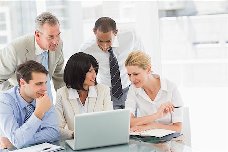 simsearch:400-07275394,k - Happy business people gathered around laptop talking in the office Stock Photo - Budget Royalty-Free & Subscription, Code: 400-07275454
