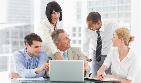 simsearch:400-07275394,k - Happy business team gathered around laptop talking in the office Stock Photo - Budget Royalty-Free & Subscription, Code: 400-07275457