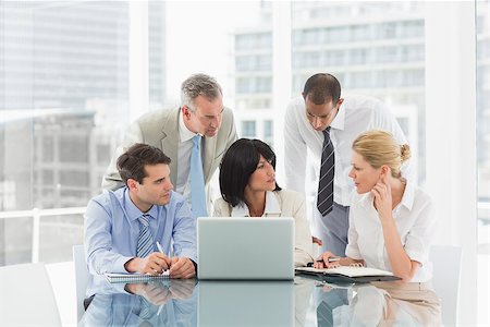 simsearch:400-07275394,k - Business people gathered around laptop discussing in the office Stock Photo - Budget Royalty-Free & Subscription, Code: 400-07275452