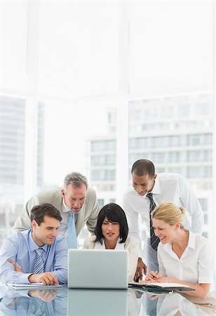 simsearch:400-07275394,k - Happy business people gathered around laptop discussing in the office Stock Photo - Budget Royalty-Free & Subscription, Code: 400-07275453