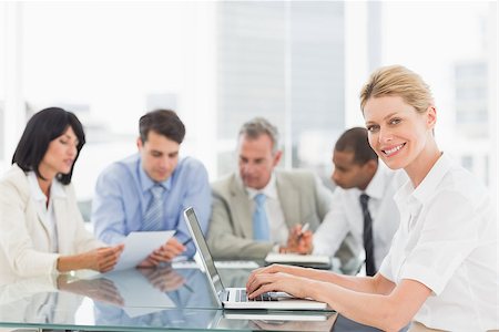 simsearch:400-07275394,k - Businesswoman using her laptop during a meeting smiling at camera in the office Stock Photo - Budget Royalty-Free & Subscription, Code: 400-07275460