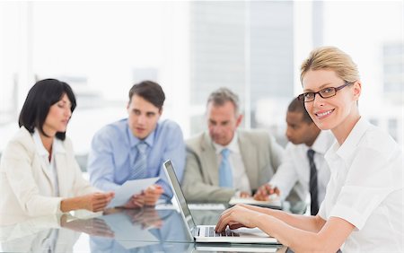 simsearch:400-07275394,k - Businesswoman using her laptop during a meeting looking at camera in the office Stock Photo - Budget Royalty-Free & Subscription, Code: 400-07275461