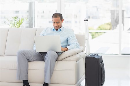 Businessman using laptop waiting to depart on business trip in the office Stock Photo - Budget Royalty-Free & Subscription, Code: 400-07275547