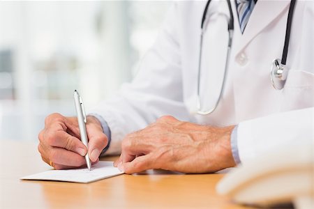 simsearch:614-06898452,k - Doctor sitting at his desk writing a prescription in his office at the hospital Stock Photo - Budget Royalty-Free & Subscription, Code: 400-07275594