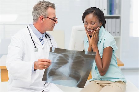 doctor speaking to young patient - Doctor showing young patient her positive chest xray in his office at the hospital Stock Photo - Budget Royalty-Free & Subscription, Code: 400-07275638