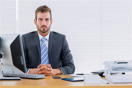 simsearch:400-07275251,k - Portrait of a serious young businessman with computer at office desk Stock Photo - Budget Royalty-Free & Subscription, Code: 400-07275661