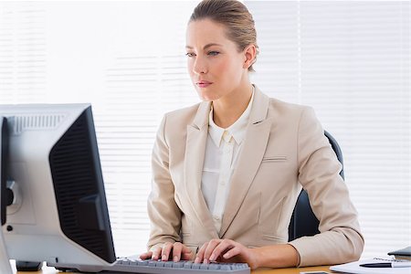 simsearch:400-07272682,k - Smartly dressed serious young businesswoman using computer at office desk Stockbilder - Microstock & Abonnement, Bildnummer: 400-07275685