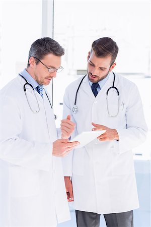 simsearch:400-07334526,k - Concentrated two male doctors using digital tablet in a bright medical office Stock Photo - Budget Royalty-Free & Subscription, Code: 400-07275984