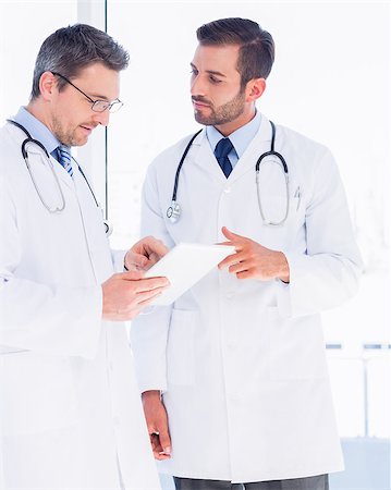 simsearch:400-07334526,k - Concentrated two male doctors using digital tablet in a bright medical office Stockbilder - Microstock & Abonnement, Bildnummer: 400-07275985
