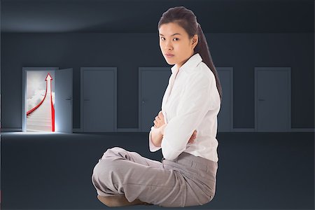 simsearch:400-07277816,k - Businesswoman sitting cross legged with arms crossed against door opening to show red arrow and sky Fotografie stock - Microstock e Abbonamento, Codice: 400-07277607