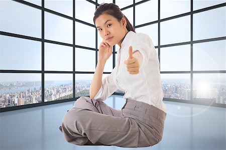 simsearch:400-07277816,k - Businesswoman sitting cross legged showing thumb up against room with large windows showing city Fotografie stock - Microstock e Abbonamento, Codice: 400-07278258