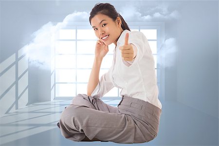 simsearch:400-07277816,k - Businesswoman sitting cross legged showing thumb up against room with holographic cloud Fotografie stock - Microstock e Abbonamento, Codice: 400-07278375