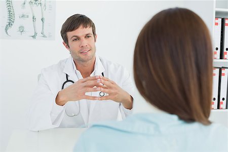 simsearch:400-07269643,k - Male doctor listening to patient with concentration at desk in medical office Fotografie stock - Microstock e Abbonamento, Codice: 400-07270798