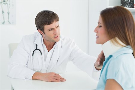 simsearch:400-07269643,k - Side view of a male doctor examining a patient's neck in medical office Fotografie stock - Microstock e Abbonamento, Codice: 400-07270815