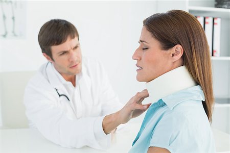 simsearch:400-07269643,k - Side view of a male doctor examining a patient's neck in medical office Fotografie stock - Microstock e Abbonamento, Codice: 400-07270818