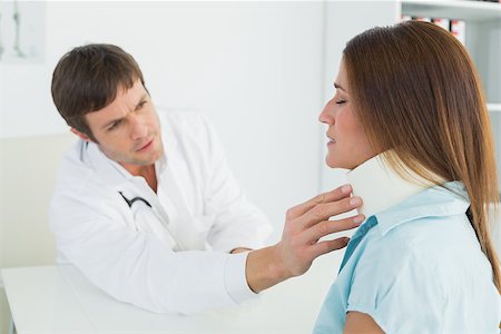 simsearch:400-07269643,k - Side view of a male doctor examining a patient's neck in medical office Fotografie stock - Microstock e Abbonamento, Codice: 400-07270812